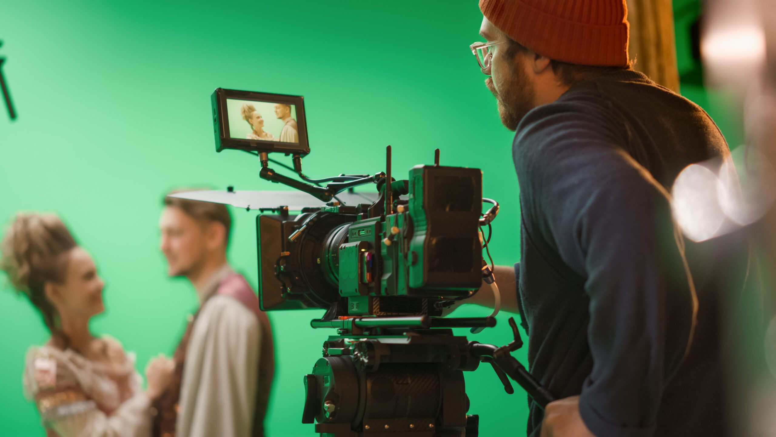 Image of a cameraman shooting couple on green screen.