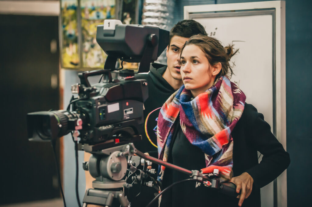 Two filmmakers adjusting camera to get the perfect shot for their short film.